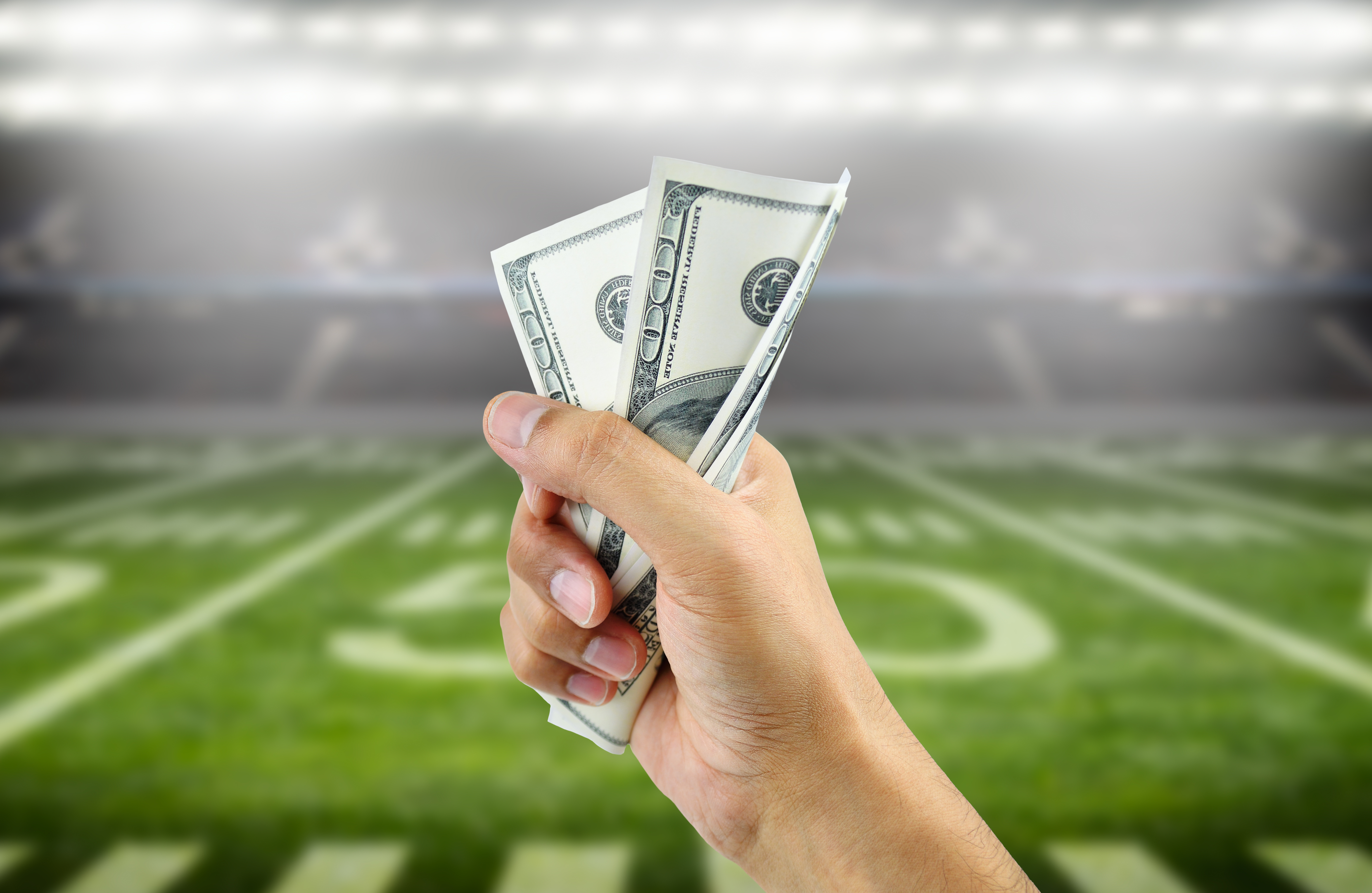 Close-up of hand holding money in sports stadium
